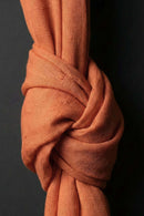 Close-up of a knotted piece of orange fabric against a black background