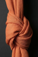Close-up of a knotted piece of orange fabric against a black background