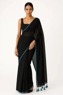 SERENITY BREEZE | Mul Cotton | Indidha Saree -  Serenity Breeze – Black Mul Cotton Saree | Indidha  Shop Serenity Breeze, a handcrafted black mul cotton saree with blue edging & tassels. Lightweight, breathable, and effortlessly elegant. Only at Indidha.