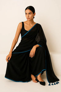 SERENITY BREEZE | Mul Cotton | Indidha Saree -  Serenity Breeze – Black Mul Cotton Saree | Indidha  Shop Serenity Breeze, a handcrafted black mul cotton saree with blue edging & tassels. Lightweight, breathable, and effortlessly elegant. Only at Indidha.