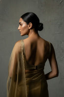Woman wearing a brown saree with a textured gray background