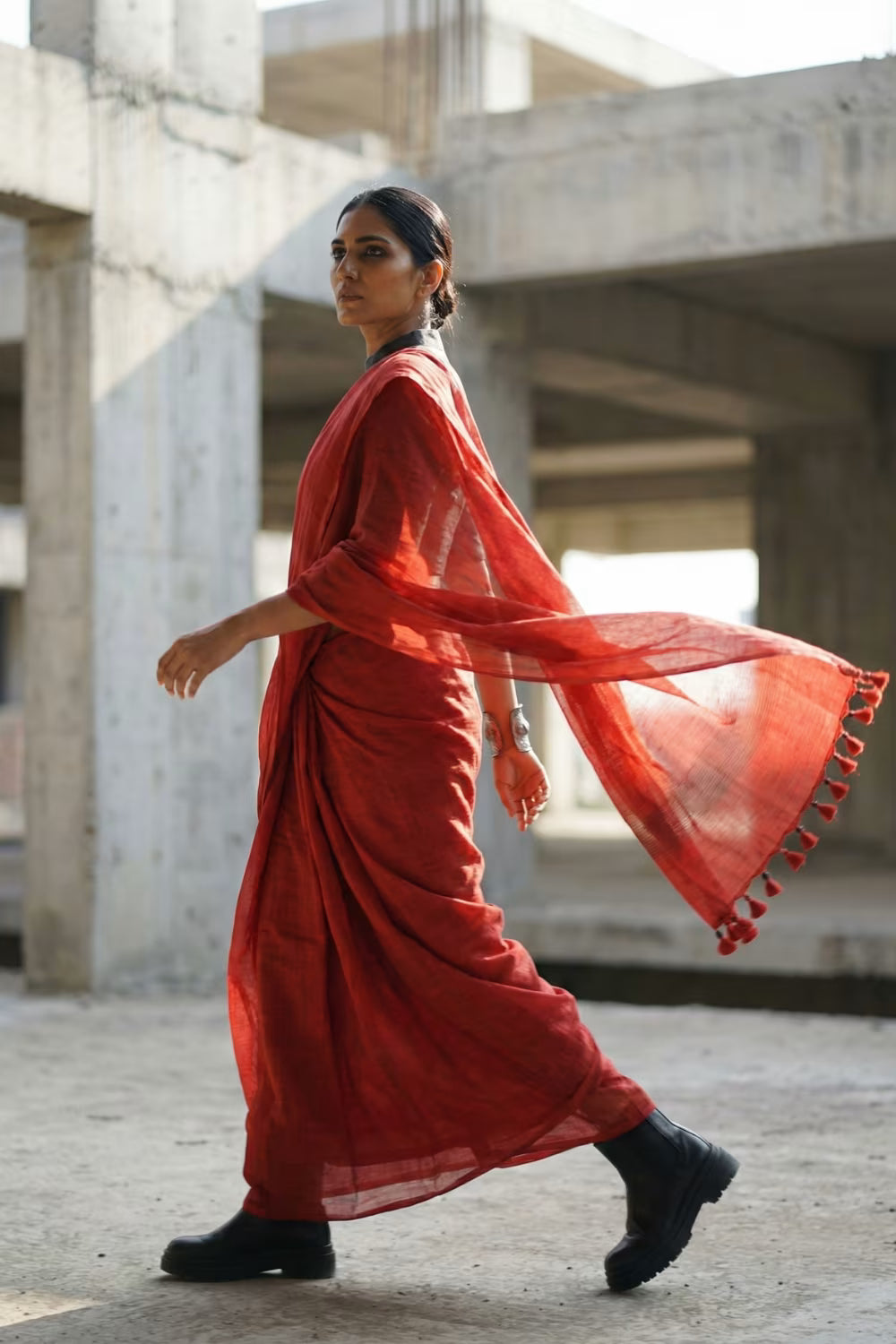 Woman in a red saree walking in an urban setting