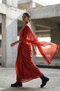 Woman in a red saree walking in an urban setting