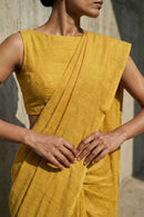 Person wearing a mustard yellow traditional outfit with a plain background