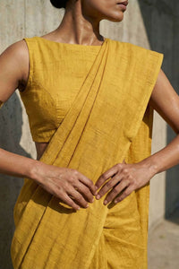 Person wearing a mustard yellow traditional outfit with a plain background
