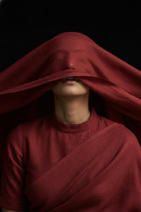 Woman wearing a red saree with a dark background