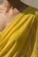 Close-up of a yellow mul cotton saree draped over shoulder with a neutral background
